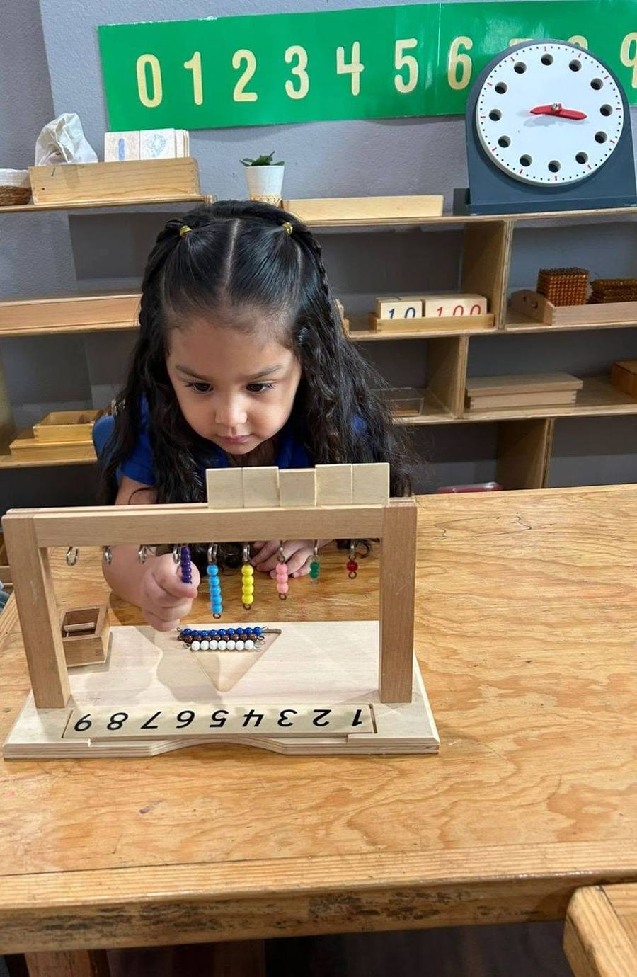 A child counts with the colored bead stair