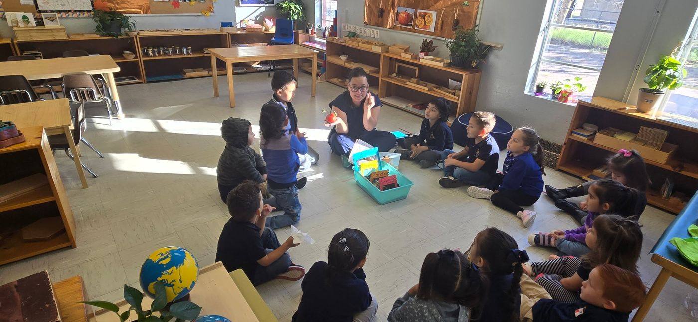 A guide leads a group lesson about plants with children seated in a circle