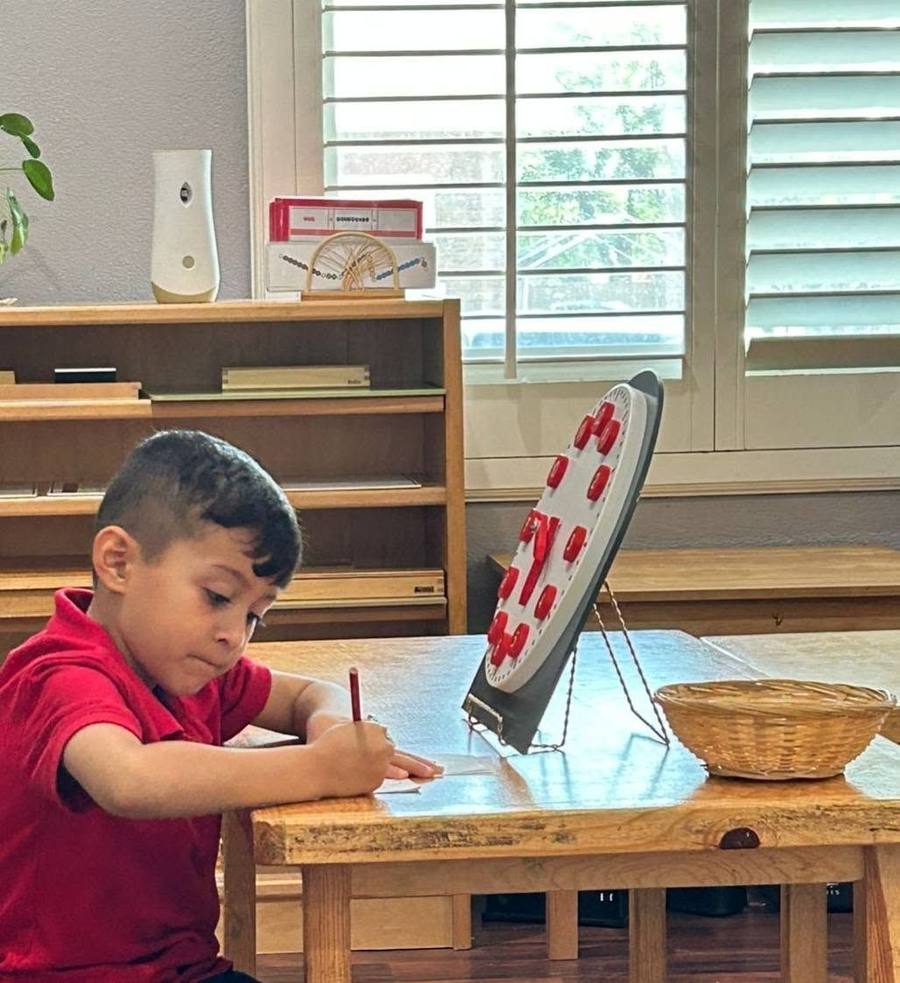A child records times from a learning clock