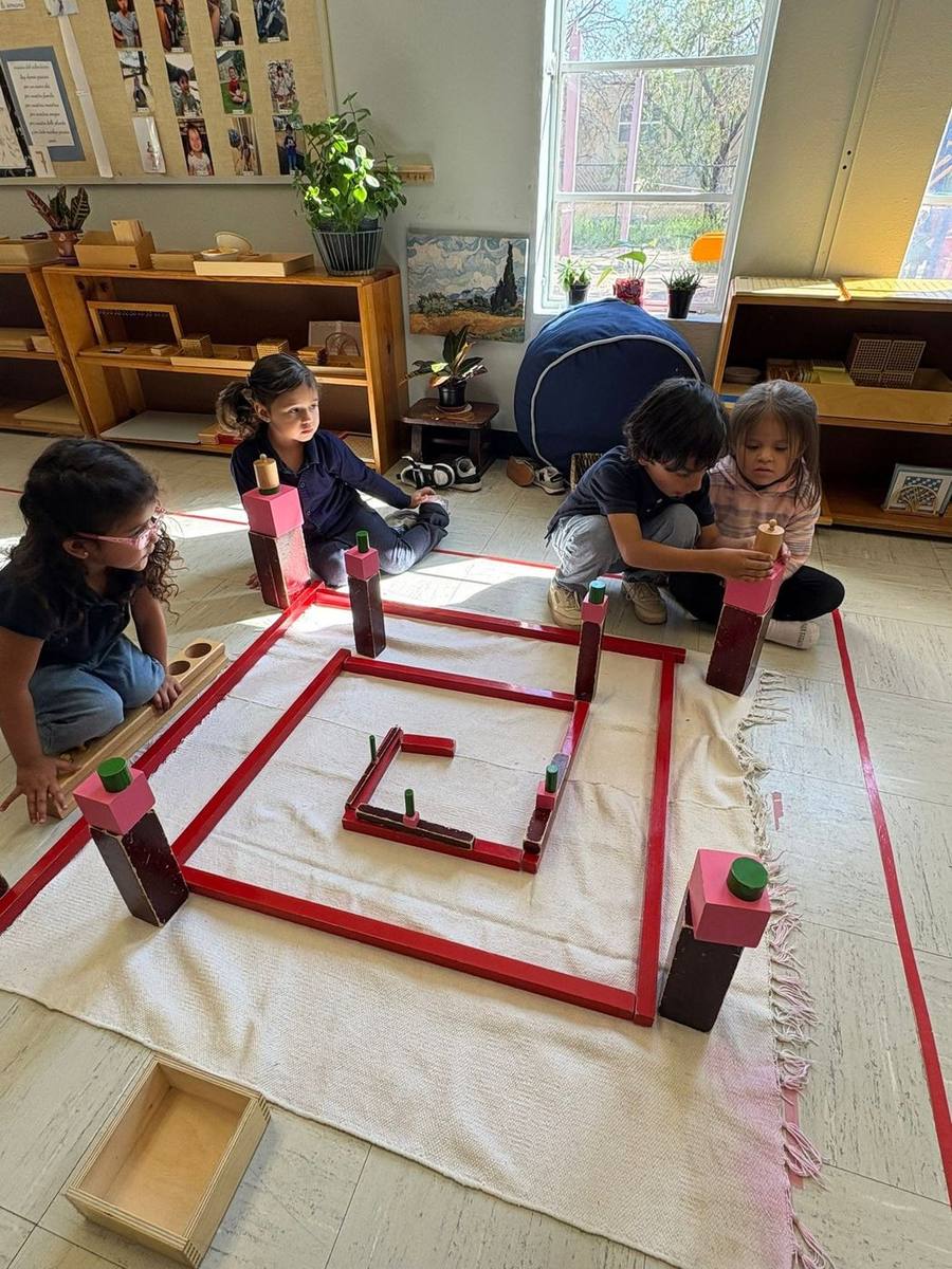 Children build a structure with the Red Rods and Pink Tower
